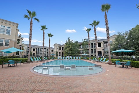 a large pool with chairs and umbrellas in front of apartment buildings a large pool with chairs and umbrellas in front of apartment buildings at The Millennium Towne Center Apartments, Baton Rouge, LA, 70806